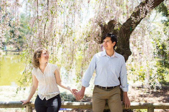Brooklyn Botanical Garden Engagement Photos Sarah and Albert holding hands in front of a white Cherry Blossom Tree
