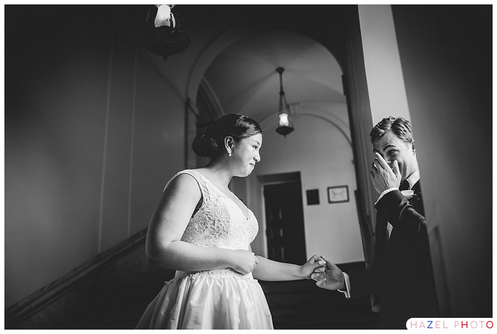 An emotional first look at a wedding. The groom wipes a tear away. Documentary wedding photography.