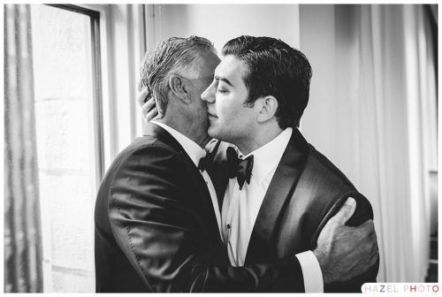 Groom embracing his father at the hotel before a State Room Wedding in Boston. Documentary wedding photography