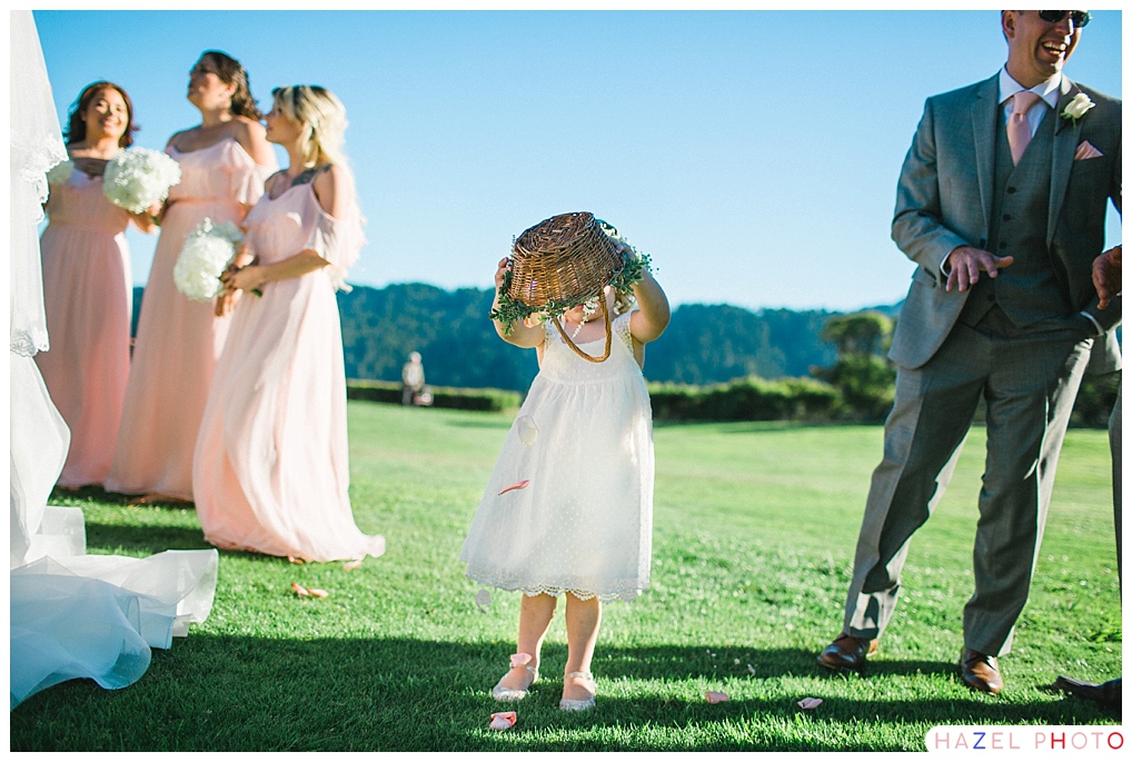 Flower girl dumping out floors in a field at a Crystal Springs Golf wedding Documentary wedding photography