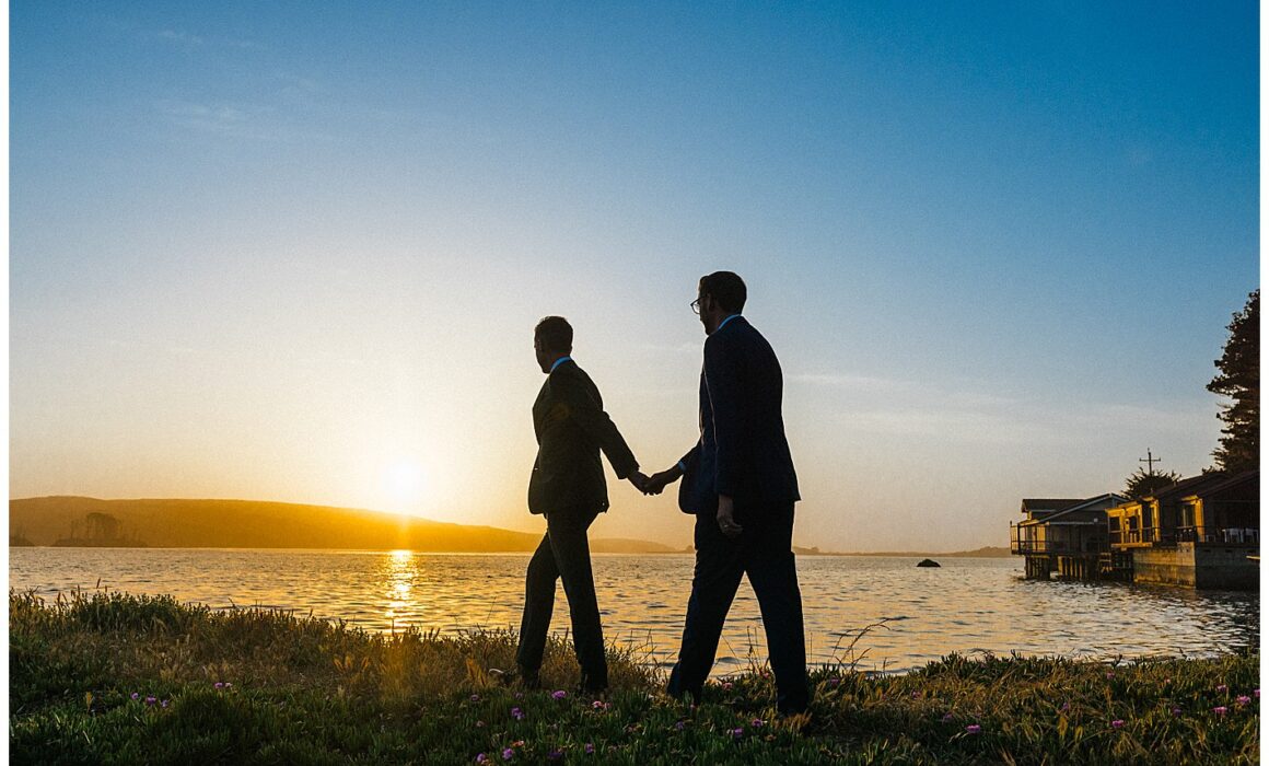 two men holding hands during sunset at straus home ranch