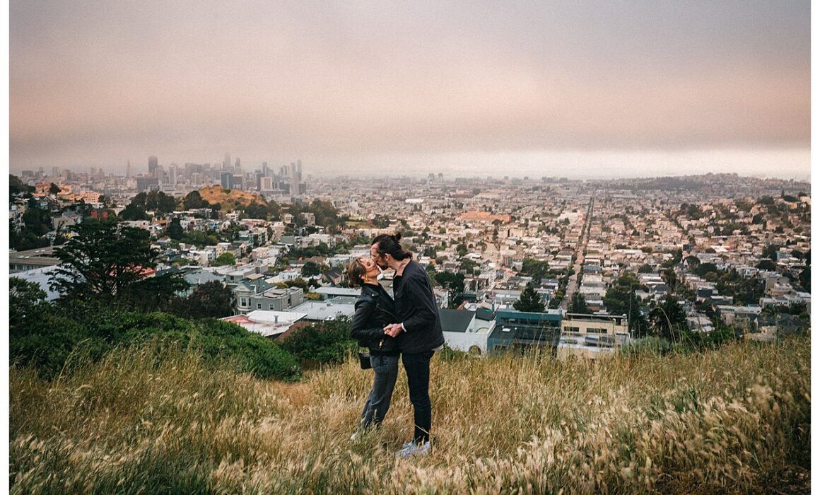 couple kissing on tank hill in San Francisco for an engagement session
