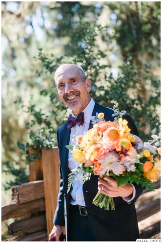 father of the groom holding flowers