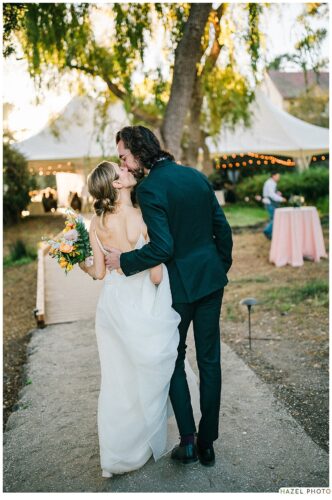 bride and groom kiss with their backs to the camera