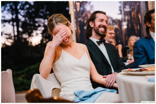 bride and groom laughing during dinner toasts