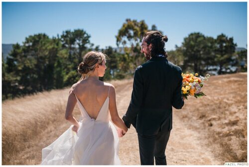 bride and groom backs to camera field landscape