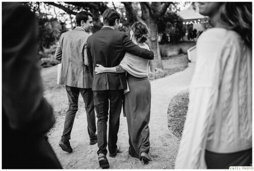 candid photo of the back of friends walking with arms around each other