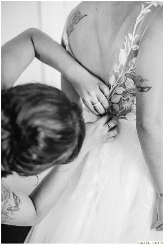 detail shot of someone helping with lace on the wedding dress