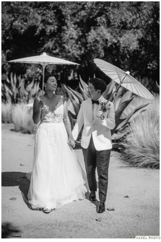 wedding portrait of couple walking with parasols