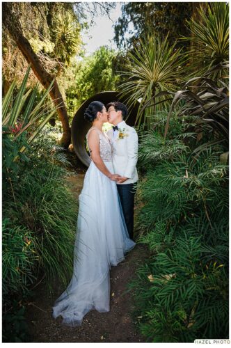 portrait of wedding couple among art in the cornerstone garden