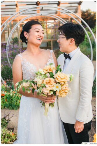golden hour portrait of newlyweds at cornerstone garden among art sculpture