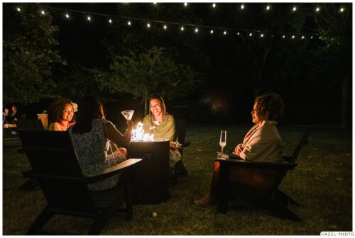wedding guests sitting in Adirondack chairs at night time