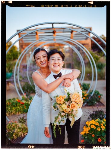 golden hour portrait of newlyweds at cornerstone garden among art sculpture