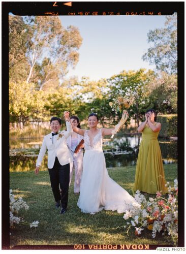 triumphant hands raised photo after the wedding ceremony, on film