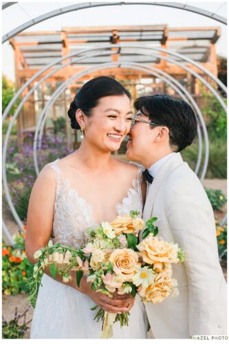 golden hour portrait of newlyweds at cornerstone garden among art sculpture
