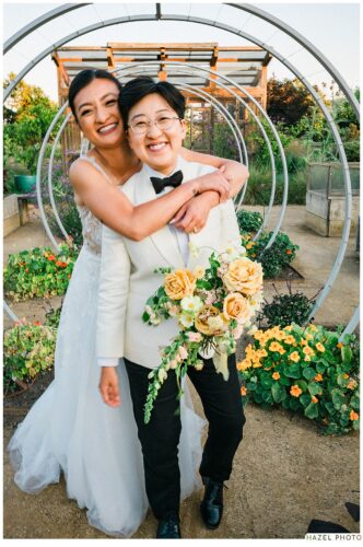 golden hour portrait of newlyweds at cornerstone garden among art sculpture