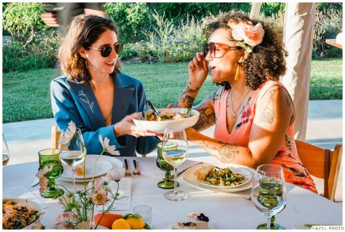 wedding guests at dinner passing plate of food